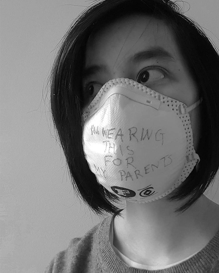 Wearing a mask with the words “Wearing this for my parents”